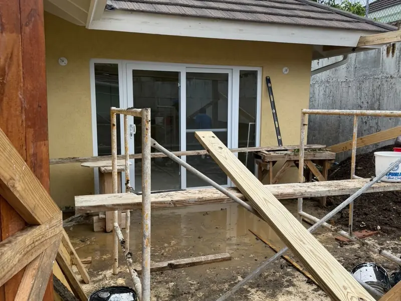 Timber formwork and props in place for an addition alongside a finished wall