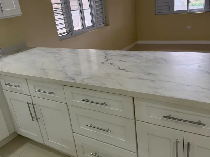 Fitted kitchen cabinetry with a marble worktop and tiled floor